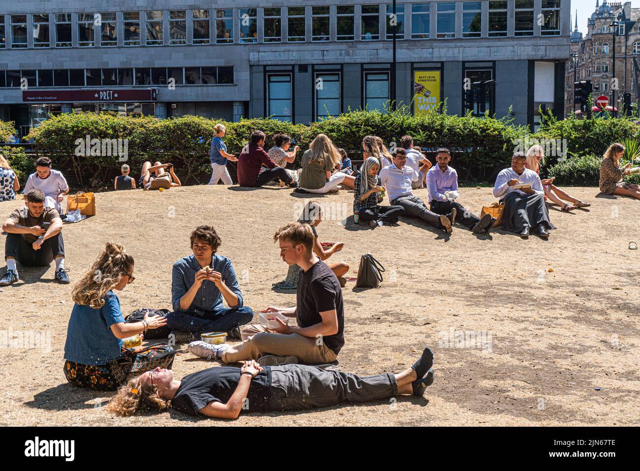 London, UK. 9 August 2022   Office workers enjoying the sunshine on the parched grass in Cavendish square London. The Uk health security agency has issued a warning as England is placed on a level 3 health alert  temperatures are expected to soar to mid 30's celsius for the next week.   Credit. amer ghazzal/Alamy Live News Stock Photo