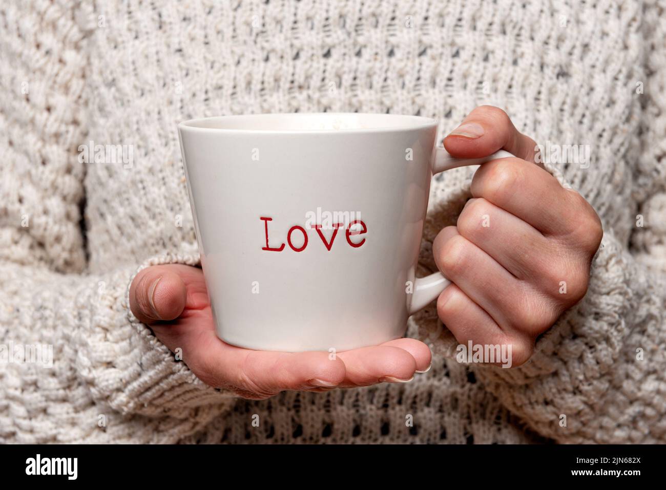 Woman holding a mug with 'love' on it. Stock Photo