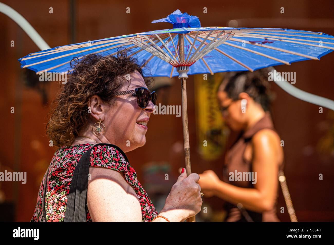 London, UK. 9 August 2022  A woman holds a parasol  to protect from the heat  in Oxford Street. The UK  health security agency has issued a warning as England is placed on a level 3 health alert  temperatures are expected to soar to mid 30's celsius for the next week.   Credit. amer ghazzal/Alamy Live News Stock Photo