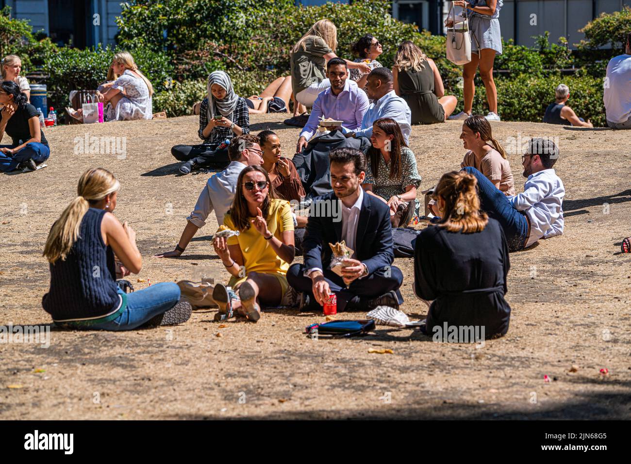 London, UK. 9 August 2022   Office workers enjoying the sunshine on the parched grass in Cavendish square London. The Uk health security agency has issued a warning as England is placed on a level 3 health alert  temperatures are expected to soar to mid 30's celsius for the next week.   Credit. amer ghazzal/Alamy Live News Stock Photo
