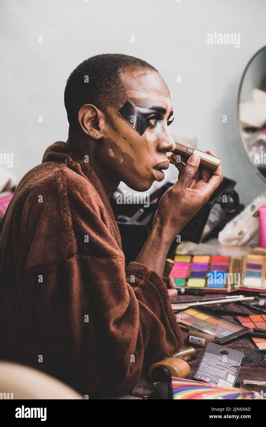 Drag Queen Applying Make-up Backstage, looking in Mirror Stock Photo