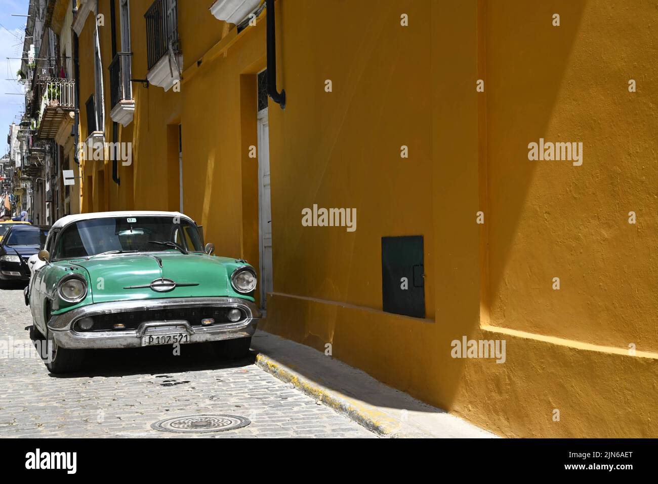 Scenic view of a vintage 1955 green and white Oldsmobile Holiday Deluxe sedan antique car in the historic center of Havana, Cuba. Stock Photo