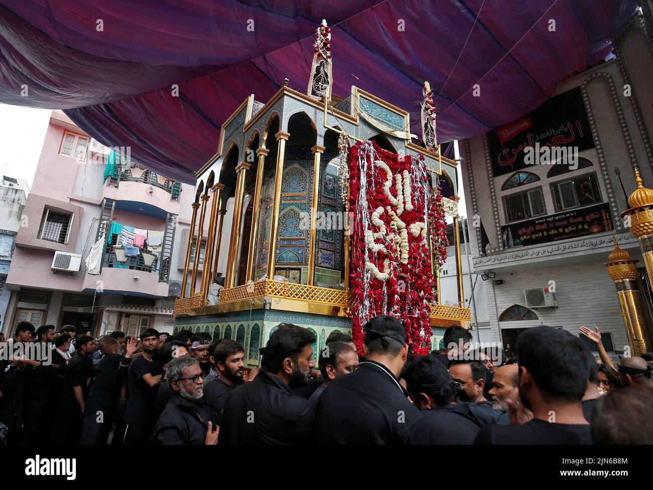 Shi'ite Muslim mourners carry a replica of the shrine of Imam Hussein during a Muharram procession marking Ashura in Ahmedabad, India, August 9, 2022. REUTERS/Amit Dave Stock Photo