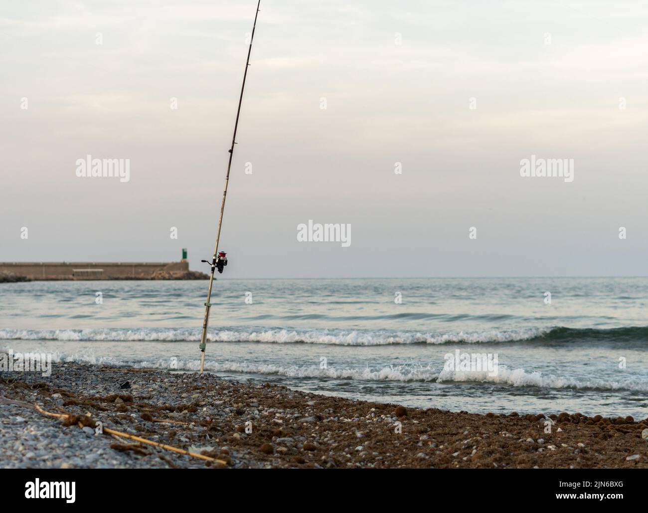 A fishing rod stuck on the beach Stock Photo Alamy