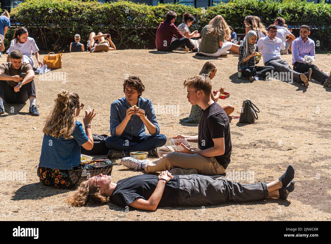 London, UK. 9 August 2022  Office workers enjoying the sunshine on the parched grass in Cavendish square London. The Uk health security agency has issued a warning as England is placed on a level 3 health alert  temperatures are expected to soar to mid 30's celsius for the next week   Credit. amer ghazzal/Alamy Live News Stock Photo