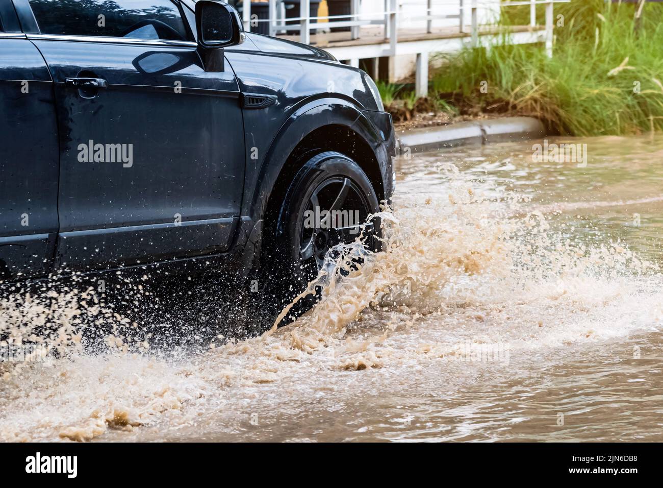 Car passing through a flooded road. Driving car on flooded road during