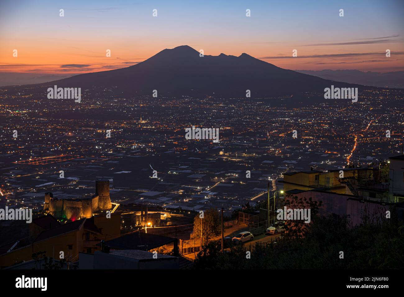 Mount Vesuvius Seen From Its South Side at sunset. Street and city Lights coming on. Stock Photo