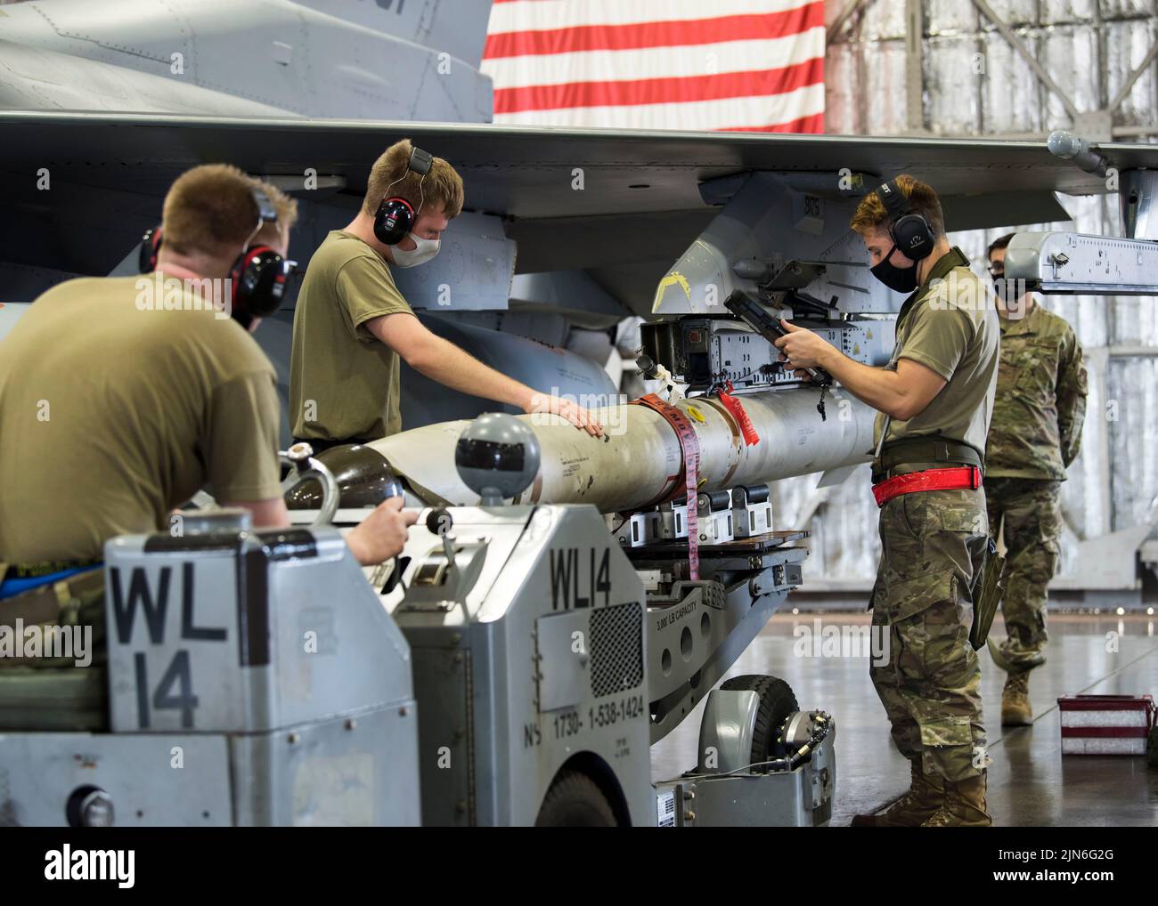 U.S. Air Force weapons load team members, from the 14th Aircraft Maintenance Unit, attach an AGM-88 HARM onto an F-16 Fighting Falcon and review technical orders during the second quarter load competition at Misawa Air Base, Japan, July 16, 2021. Technical orders are checklists Airmen are required to follow to ensure all procedures are completed properly. (U.S. Air Force photo by Airman 1st Class Leon Redfern) Stock Photo