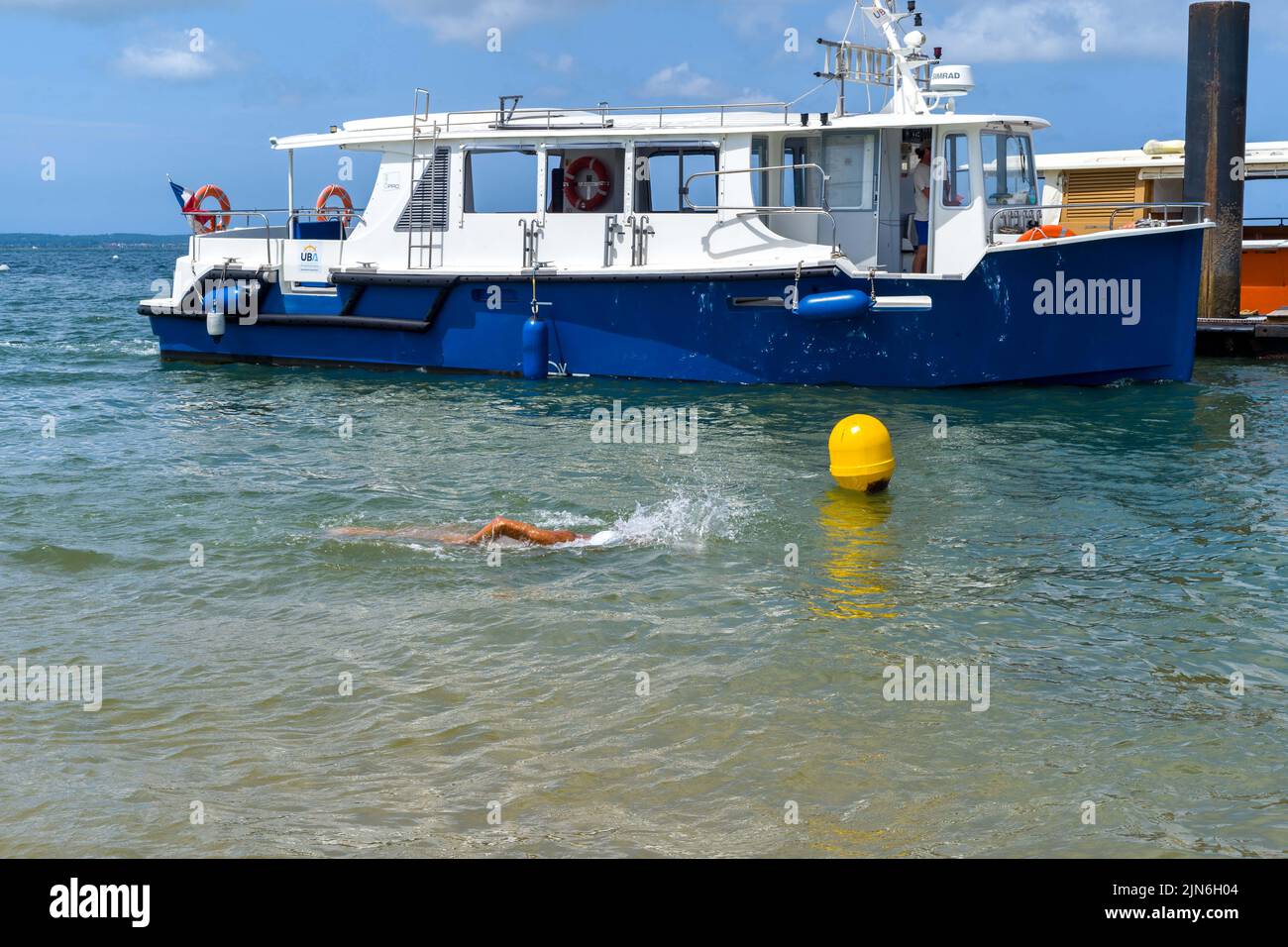 A man swims in front of a cab boat. Arcachon beach, the Belisaire pier, the embarkations, the lovers, the bathers, a day at the beach. August 04, 2022. Photo by Patricia Huchot-Boissier/ABACAPRESS.COM Stock Photo