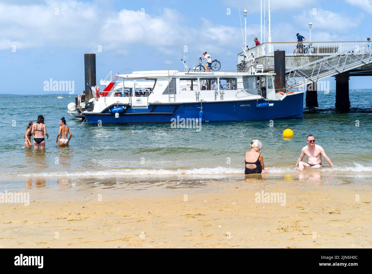 People bathing in front of a cab boat. Arcachon beach, the Belisaire pier, the embarkations, the lovers, the bathers, a day at the beach. August 04, 2022. Photo by Patricia Huchot-Boissier/ABACAPRESS.COM Stock Photo
