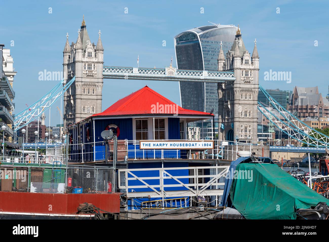 The Harpy Houseboat, off Butler's Wharf in Shad Thames, with Tower Bridge, 20 Fenchurch Street, Walkie Talkie building beyond. Restored floating home Stock Photo