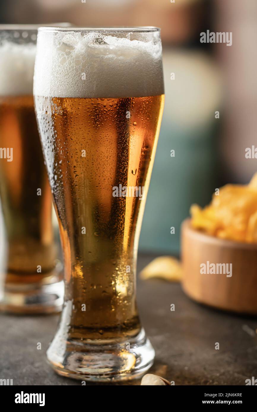 Full glasses of light beer with drops on the side in bar close up. Alcohol, entertainment, traditional drinks, Oktoberfest atmosphere concept. Vertica Stock Photo