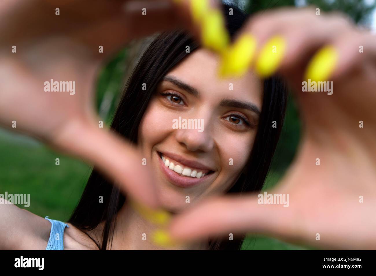 Beautiful Girl with smiling and making heart with her hands Stock Photo
