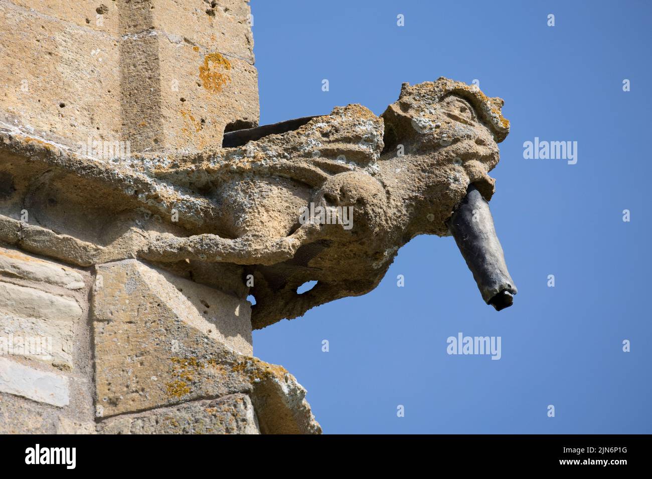 Weathered ancient gargoyle against blue sky on All Saints Church Weston on Avon Warwickshire UK Stock Photo