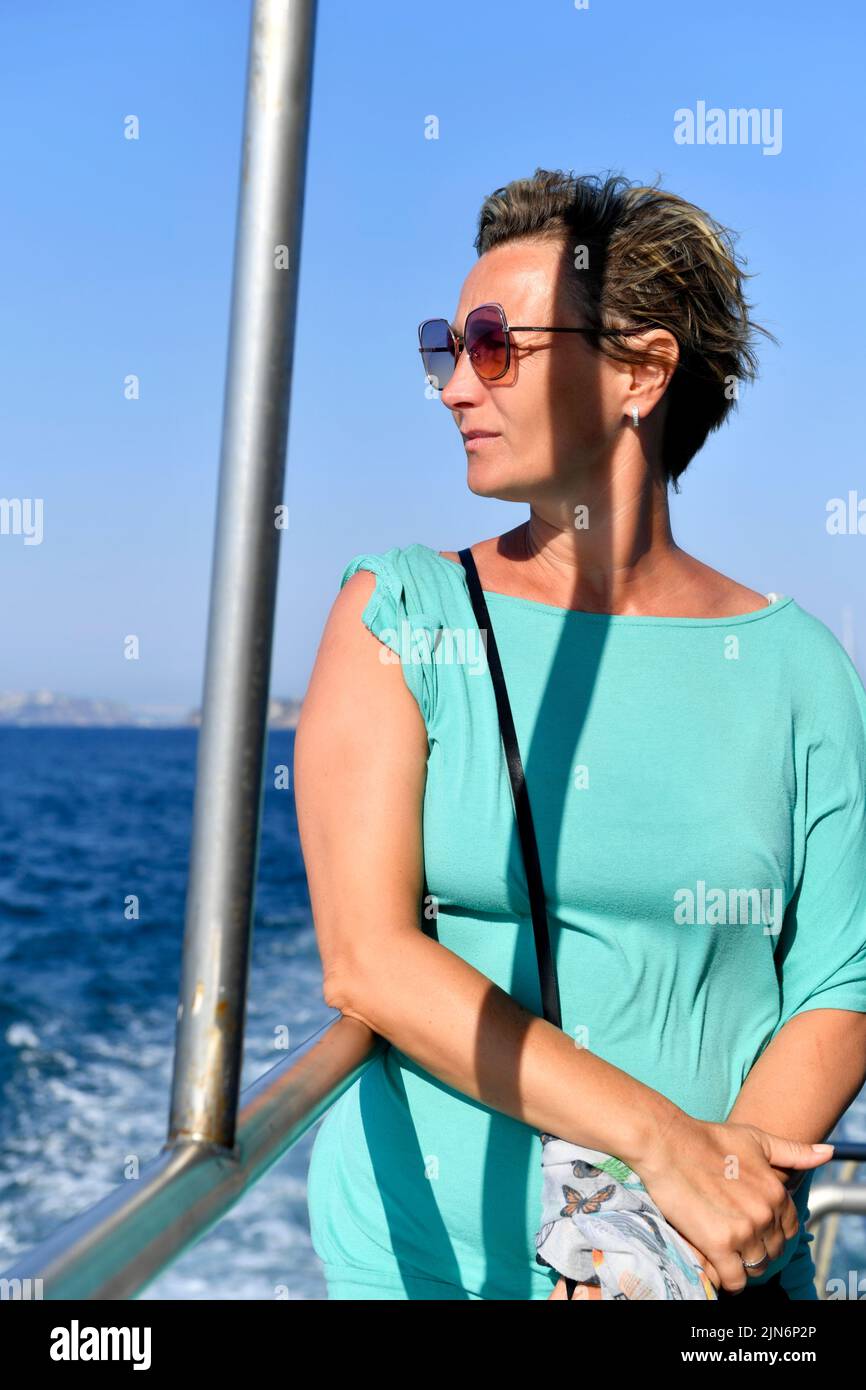 middle-aged good looking woman on the board looking on the sea Stock Photo