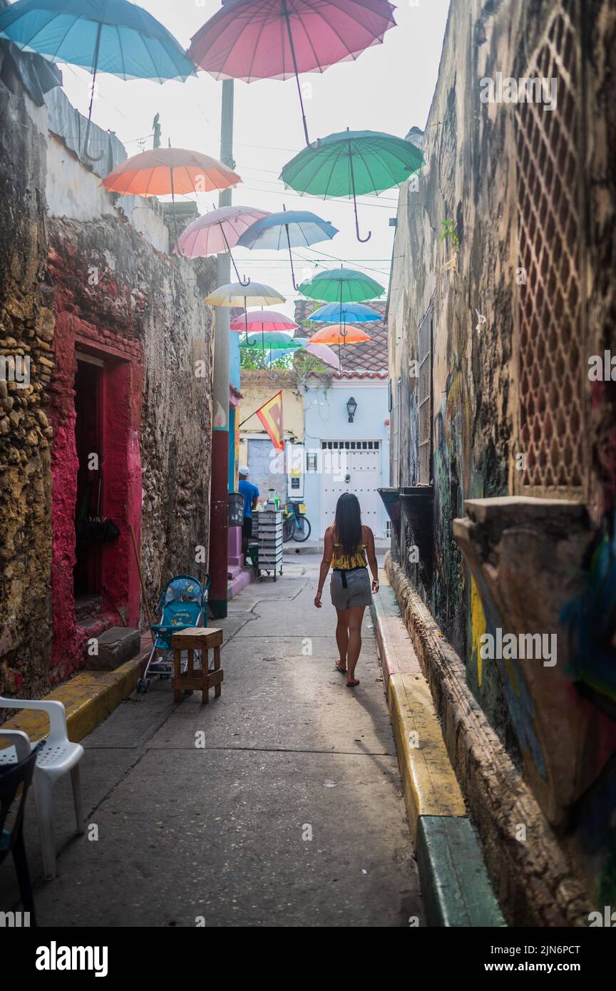 Young woman walking the popular Umbrella-covered street in the cool neighbourhood of Getsemani, Cartagena de Indias, Colombia Stock Photo