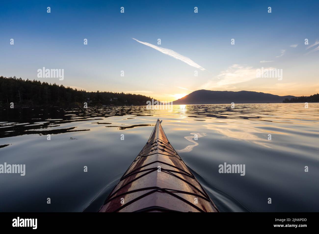 Sea Kayak paddling in the Pacific Ocean. Colorful Sunset Sky. Stock Photo
