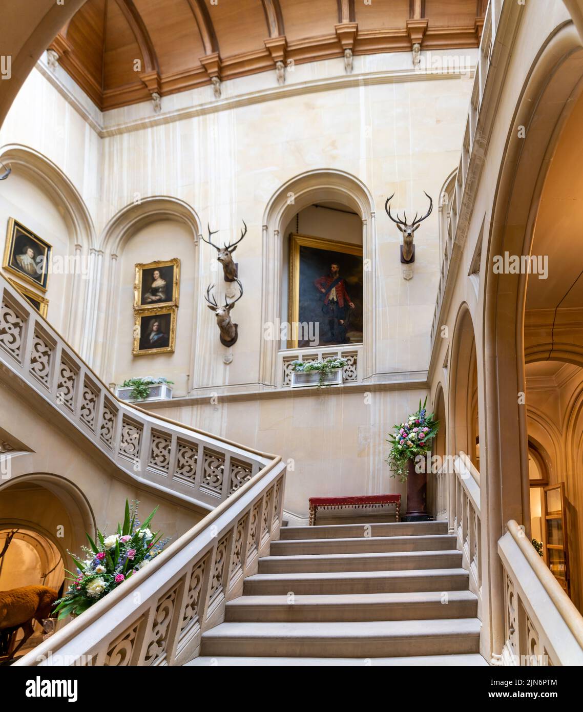 Golspie, United Kingdom - 25 June, 2022: interior view of the foyer and entrance staircase with paintings and hunting trophies in Dunrobin Castle Stock Photo