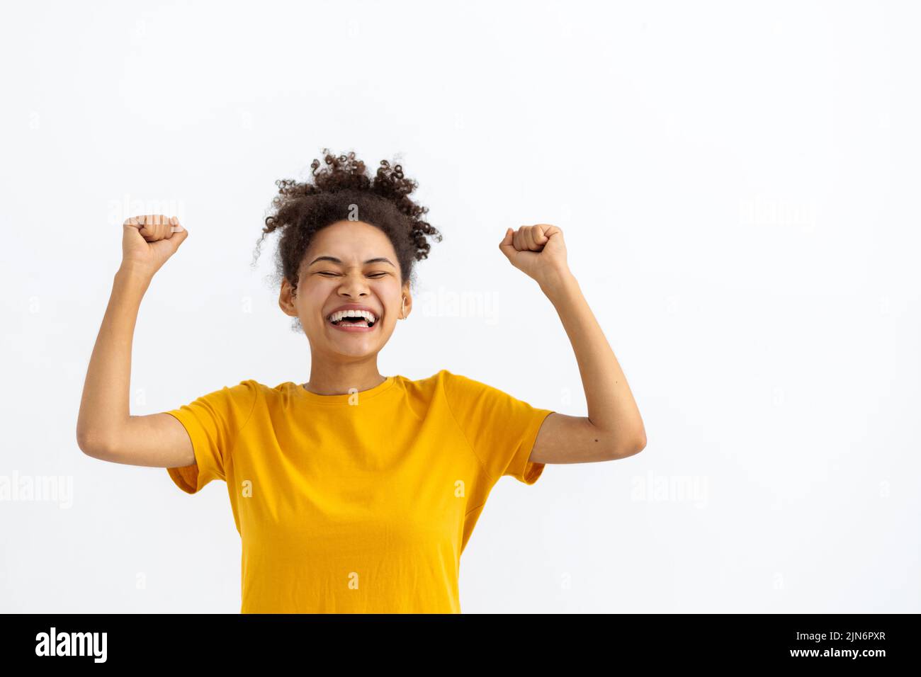 funny young African American woman celebrating victory on a white background Stock Photo