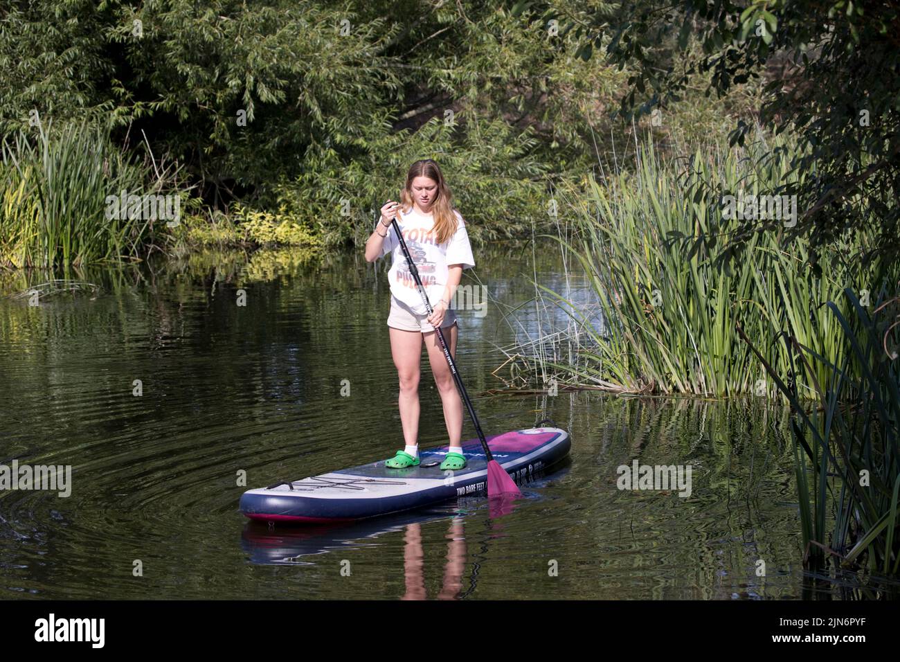 Young woman paddleboarding on the River Avon Weston on Avon Warwkickshire UK Stock Photo