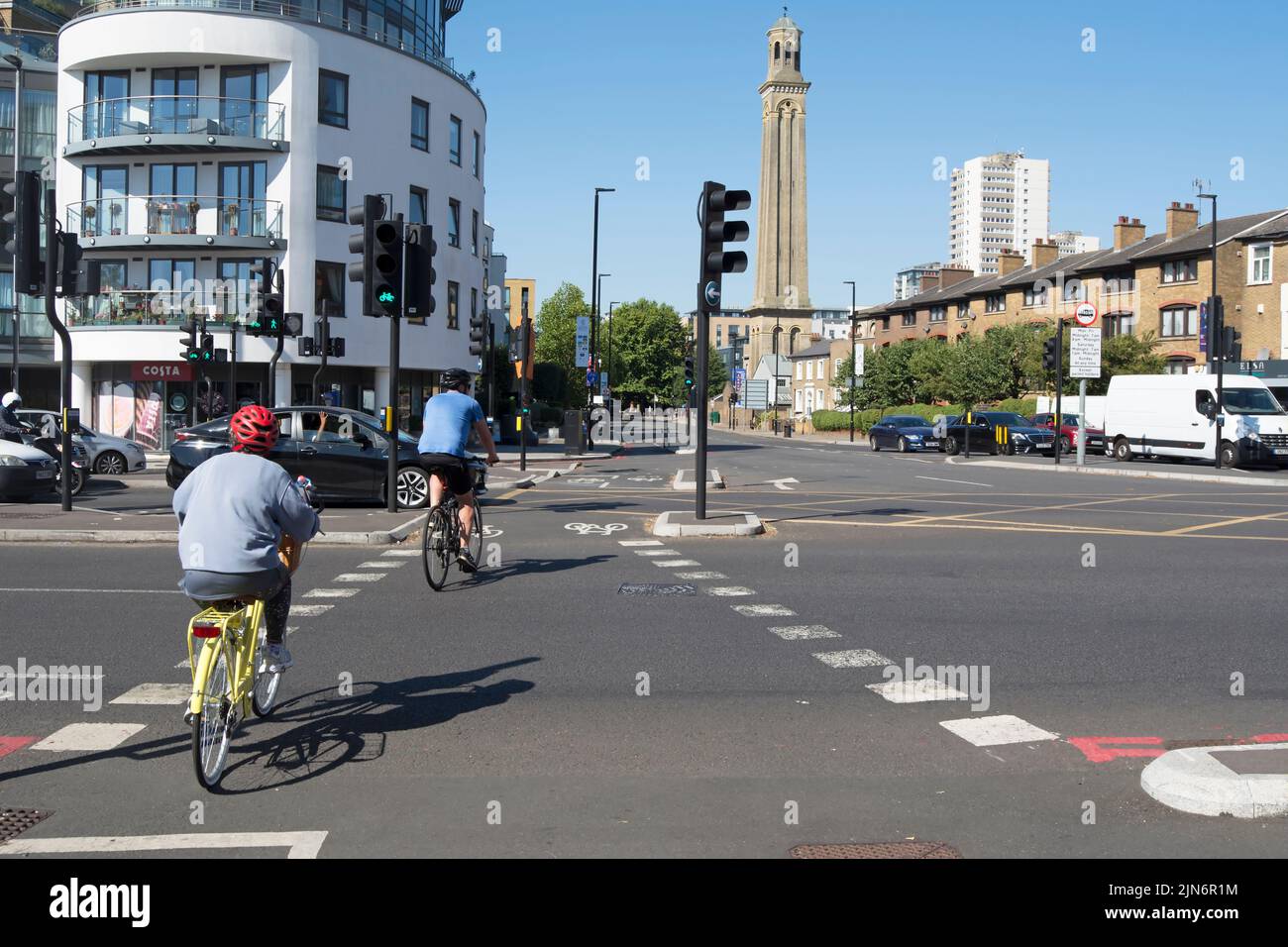 male and female cyclists cross a busy junction on the north side of kew bridge, london, england, using dedicated cycle signals and lanes Stock Photo
