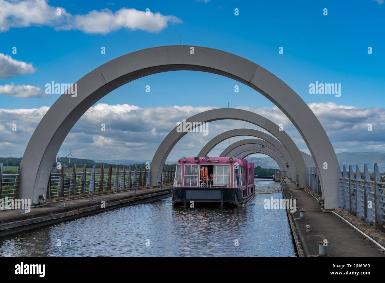 Falkirk, United Kingdom - 19 June, 2022: view of a tourist boat cruise on the Union Canal after leaving. The Falkirk Wheel hydraulic boat lift Stock Photo