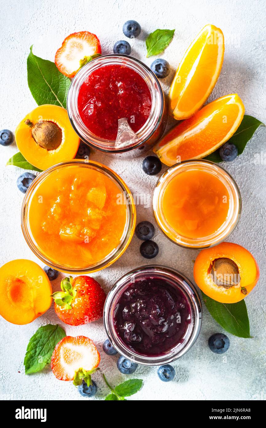 Homemade jam in glass jars at white table Stock Photo Alamy