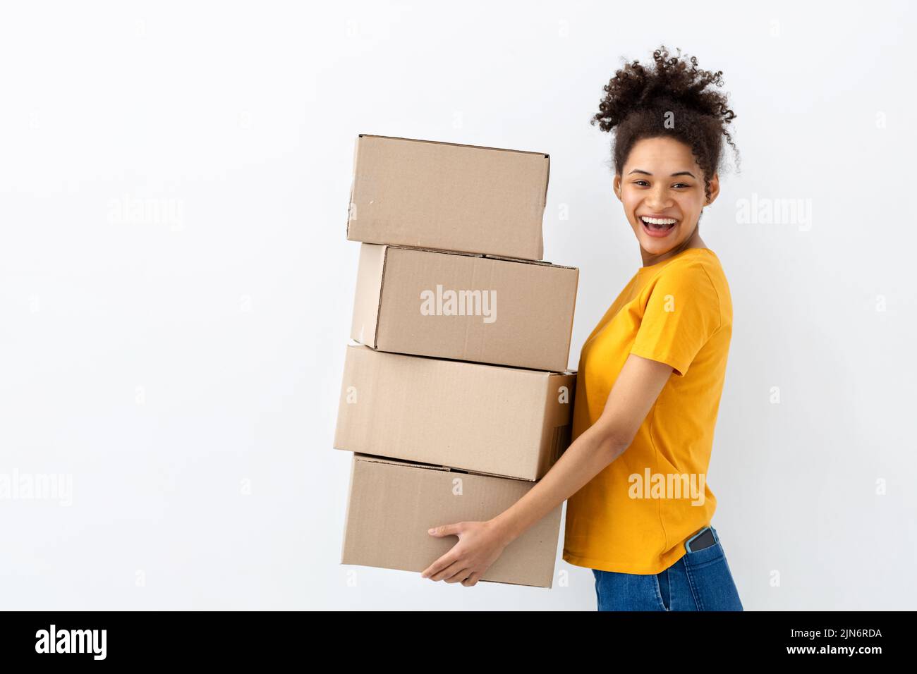 Young happy African American woman with stack of cardboard boxes on white background Copy space Stock Photo