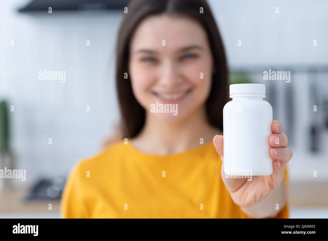 Happy young woman holding bottle of dietary supplements or vitamins in her hands Healthy lifestyle Stock Photo