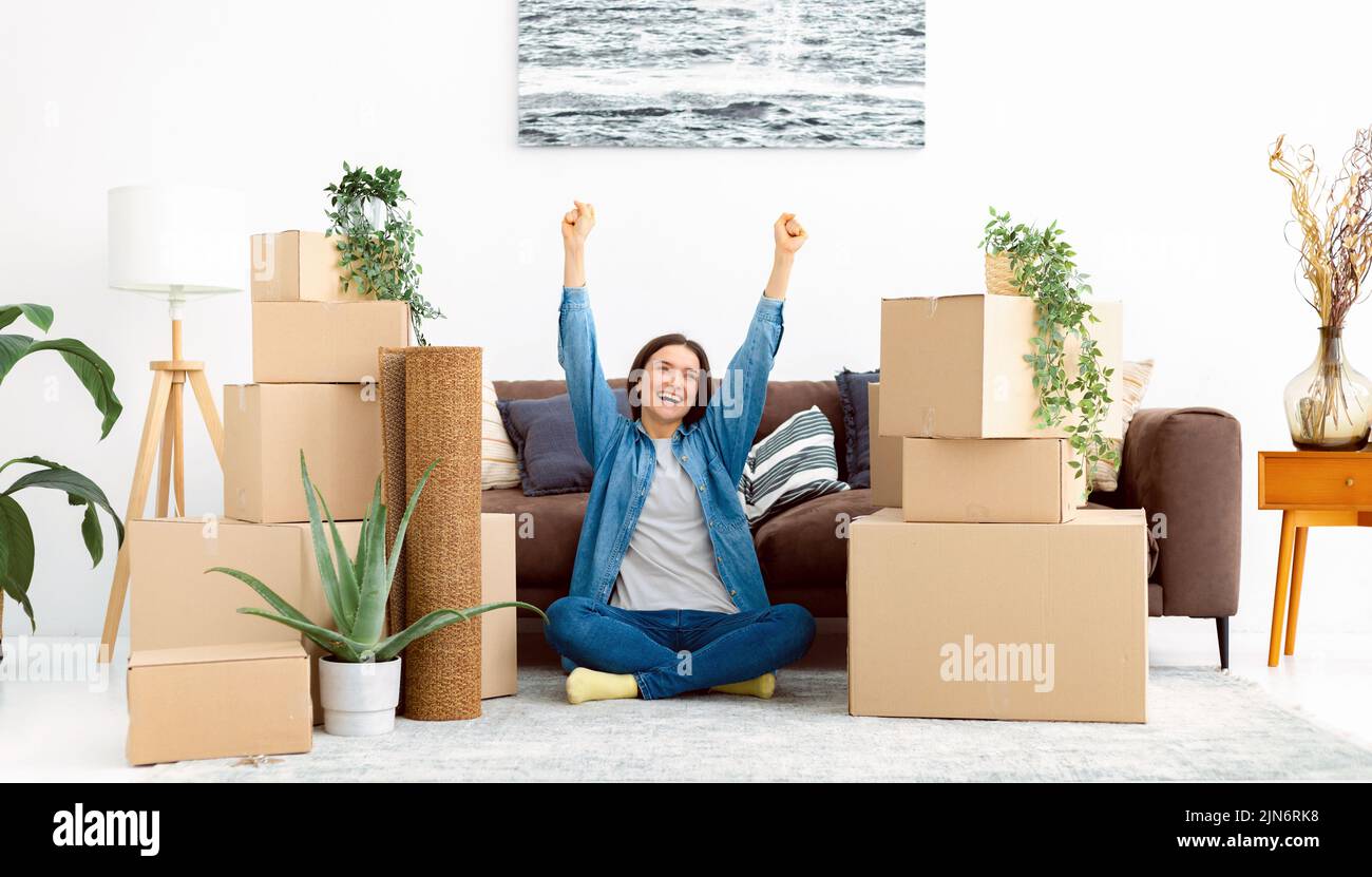 Happy smiling woman with a stack of cardboard boxes Moving to a new house, rent Stock Photo