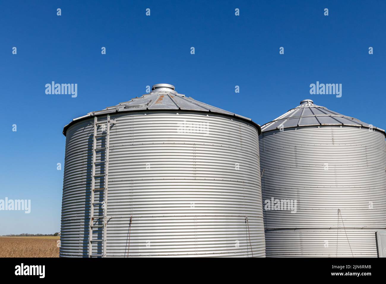 Grain bin storage system on farm. Agriculture and farming equipment safety, maintenance, and