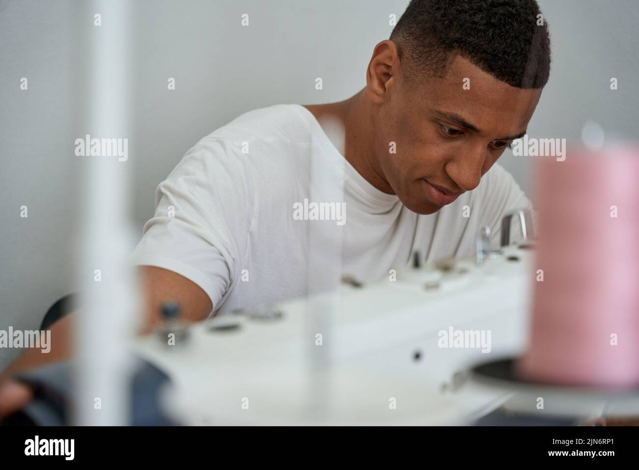 Young male tailor working in modern atelier Stock Photo