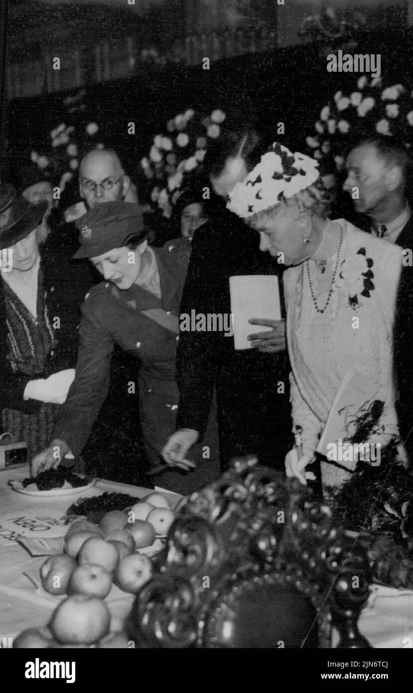Queen Mary At Vegetables Show -- Queen Mary interested in the exhibits. Queen Mary visited the first big wartime garden produce show which is being held at Cheltenham Organised by the Cheltenham Council proceeds go to the Red Cross. September 26, 1941. (Photo by Fox Photos). Stock Photo