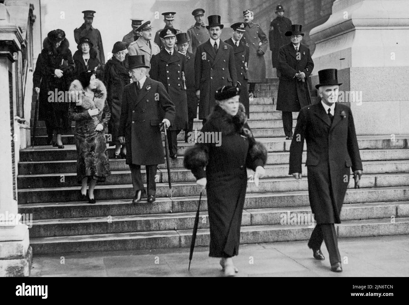 Armistice Day In London -- H.M. the Queen leaving the Home Office with Sir John Simon after watching the ceremony at the Cenotaph. Group at back includes the Duke and Duchess of York, the Duke of Kent, Prince Arthur of Connaught, Princess Helena Victoria and Princess Marie Louise. November 11, 1935. (Photo by The International Graphic Press Ltd.). Stock Photo
