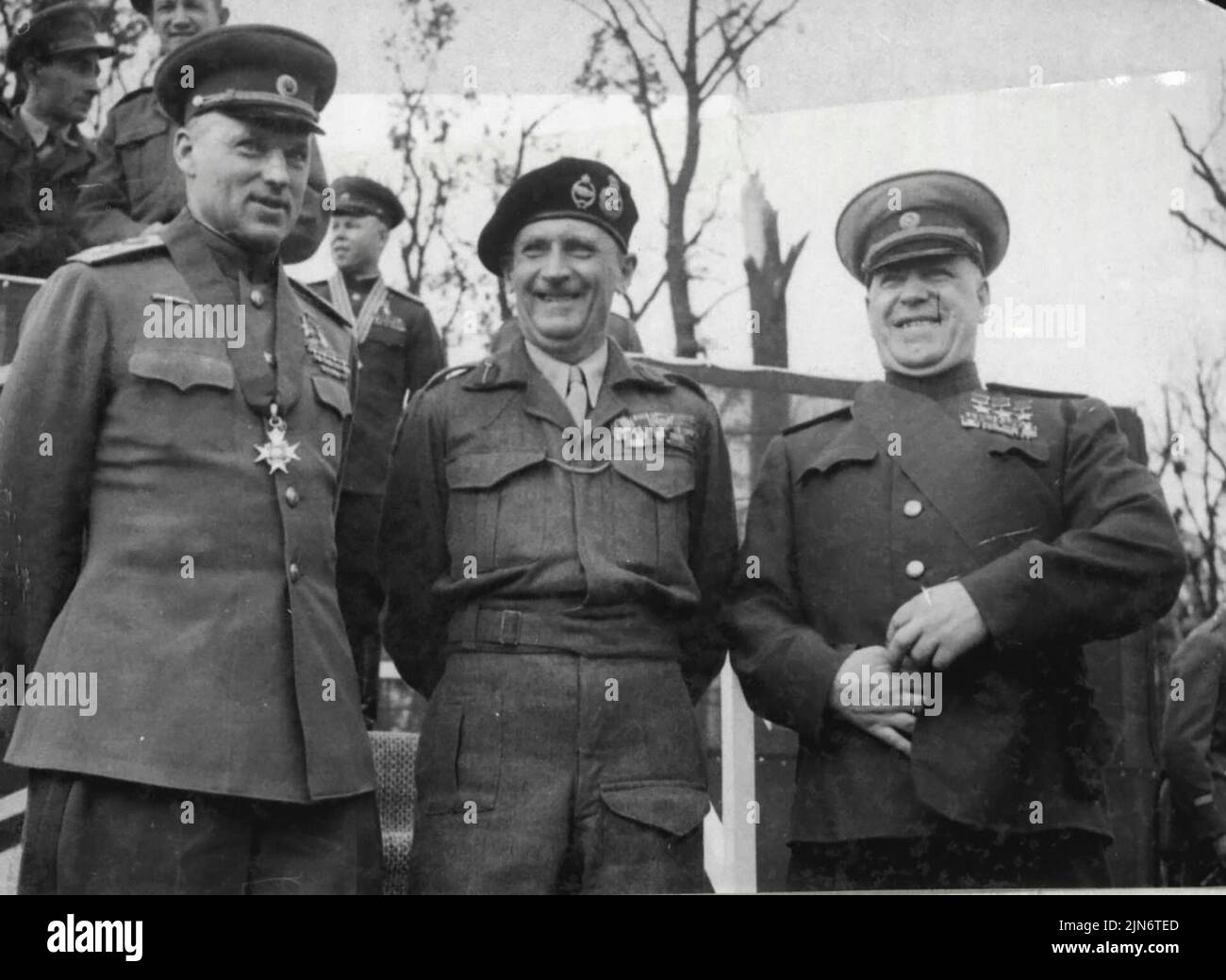 Monty Decorates Red Army Generals - (left to right) - Marshal Rokossovsky, wearing the neck band of the order of knight commander of the bath, Field - Marshal Montgomery, and Marshal Zhukov, wearing the sash of the order of knight grand cross of the order of the bath, on the Rostrom after taking the salute at the March past of Grenadier guards.Field-Marshal Montgomery decorated Marshal Zhukcy with the order of the knight Grand cross of the order of the bath, and Marshal Rokossovsky with knight commander of the bath, at a ceremonial parade in Berli, yesterday, July 12. Montgomery also invested Stock Photo