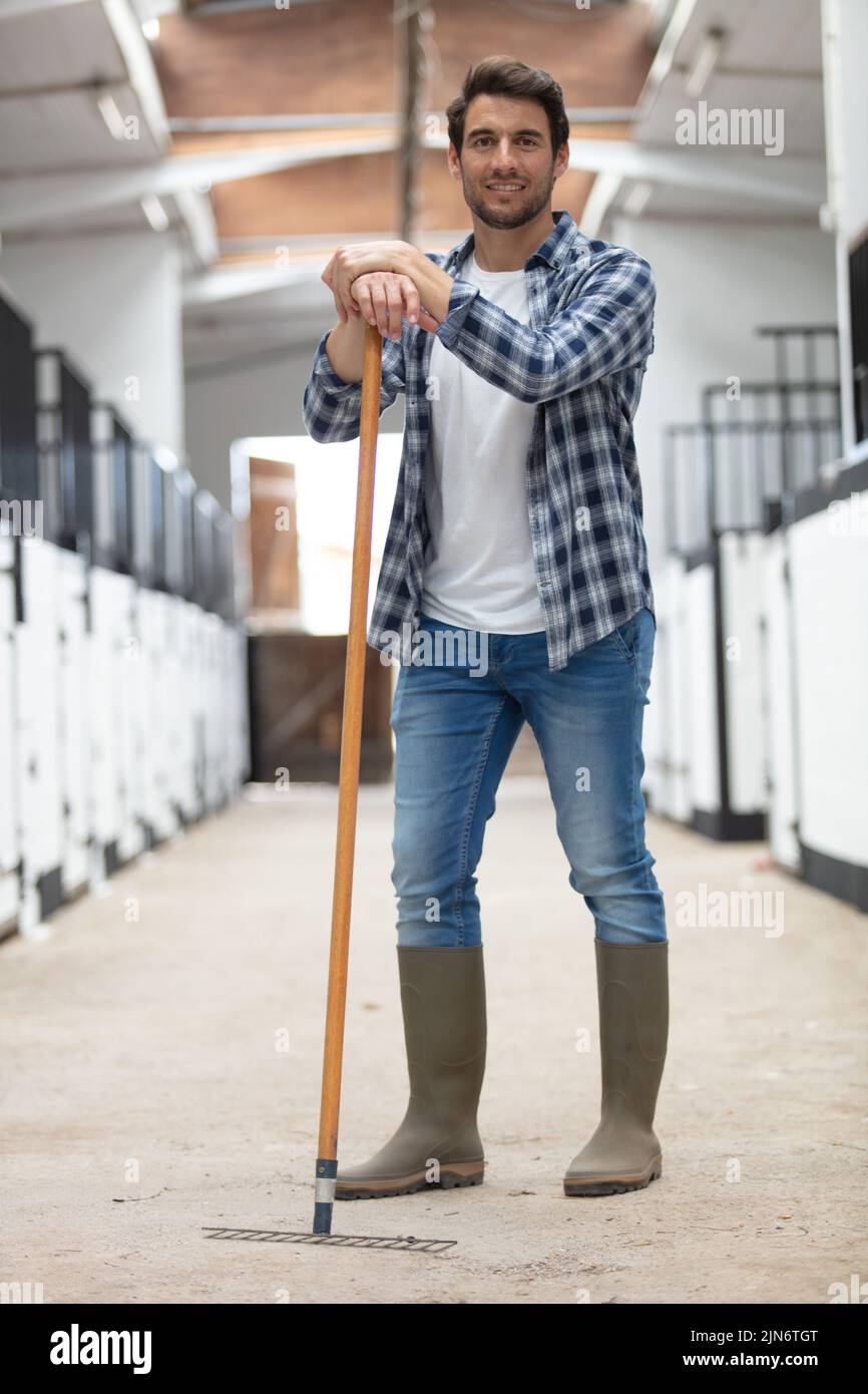 handsome groom posing in horse riding club Stock Photo