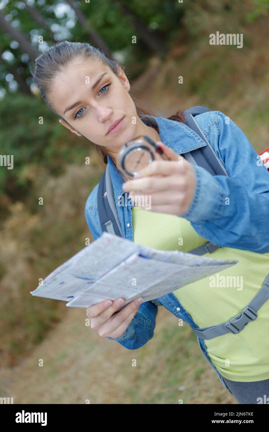portrait of young female hiker holding compass and map Stock Photo - Alamy