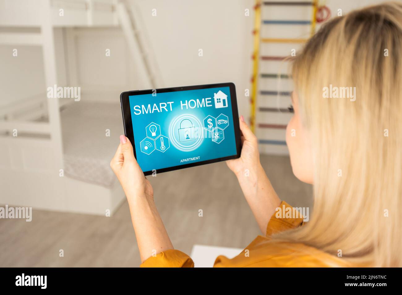 Woman using smart wall home control system. Stock Photo