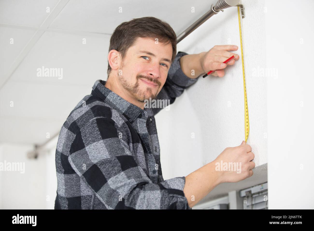 man is measuring vertical blinds Stock Photo