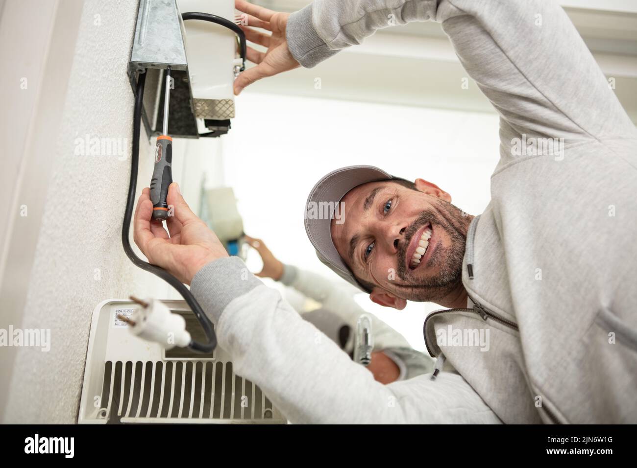 man installing an electric handdryer Stock Photo Alamy