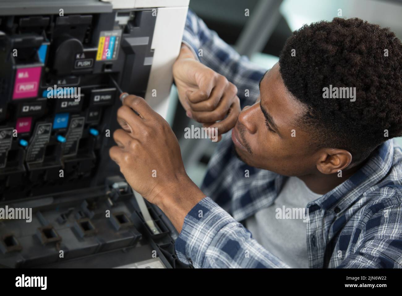 male technician checking ink levels in photocopier Stock Photo