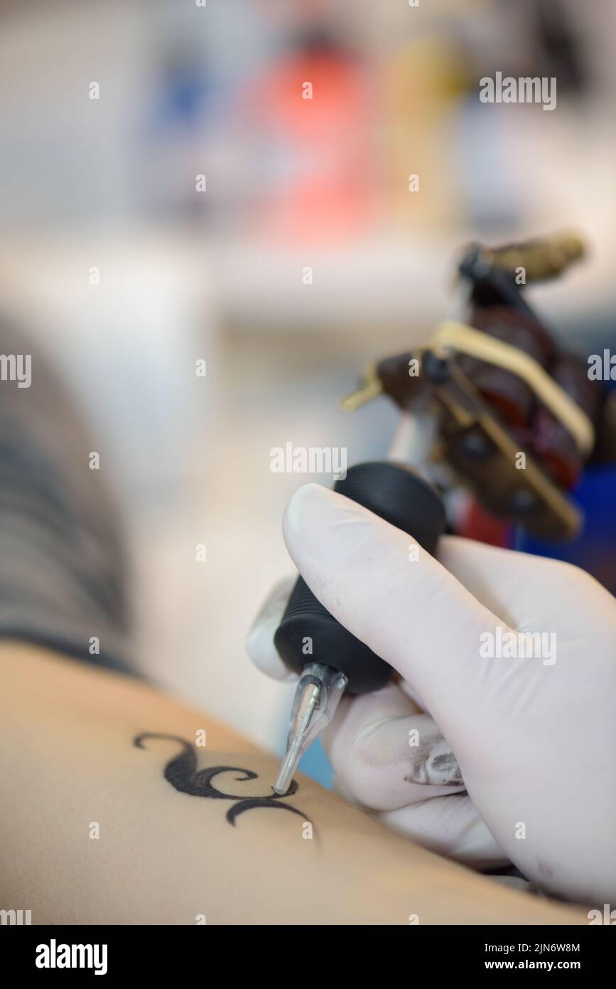 she is putting a small tattoo Stock Photo