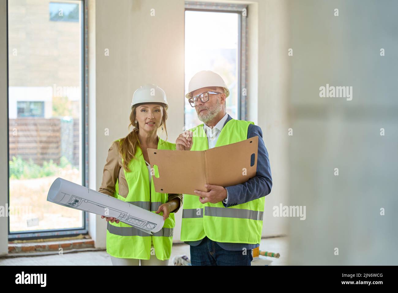 Realtor with drawings, and foreman with folders in their hands Stock Photo