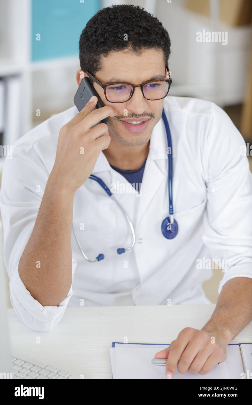 close up of handsome man doctor using mobile phone Stock Photo