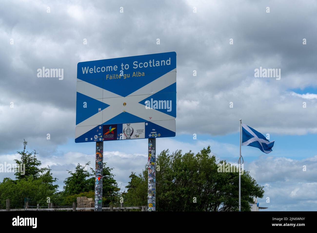 Jedburgh, United Kingdom - 18 June, 2022: Scottish flag and Welcome to Scotland sign in English and Scots at a rest stop at the Scottish Borders Stock Photo