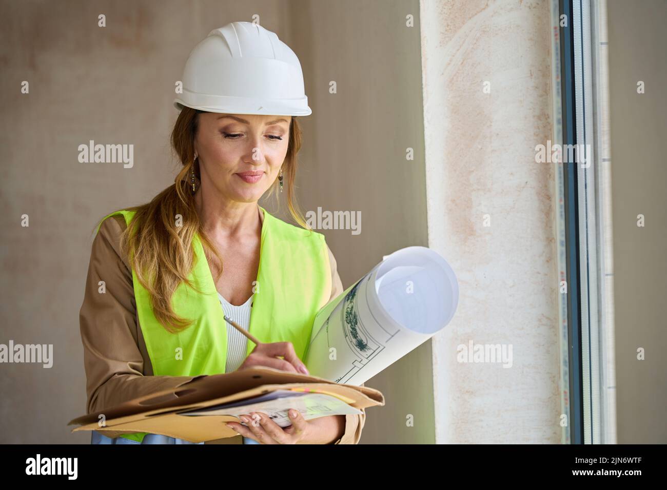 Portrait of pensive woman realtor with folders and projects Stock Photo
