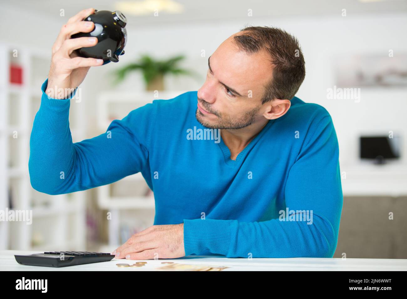 man looking at his empty piggybank Stock Photo - Alamy