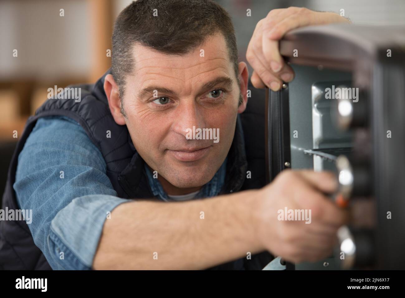 man repairing an electrical oven Stock Photo