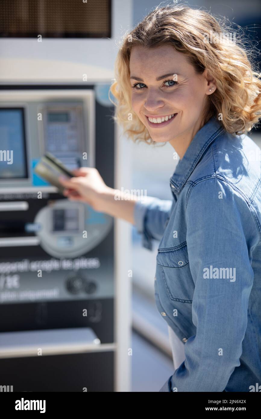mid adult woman pays for gasoline at the station Stock Photo