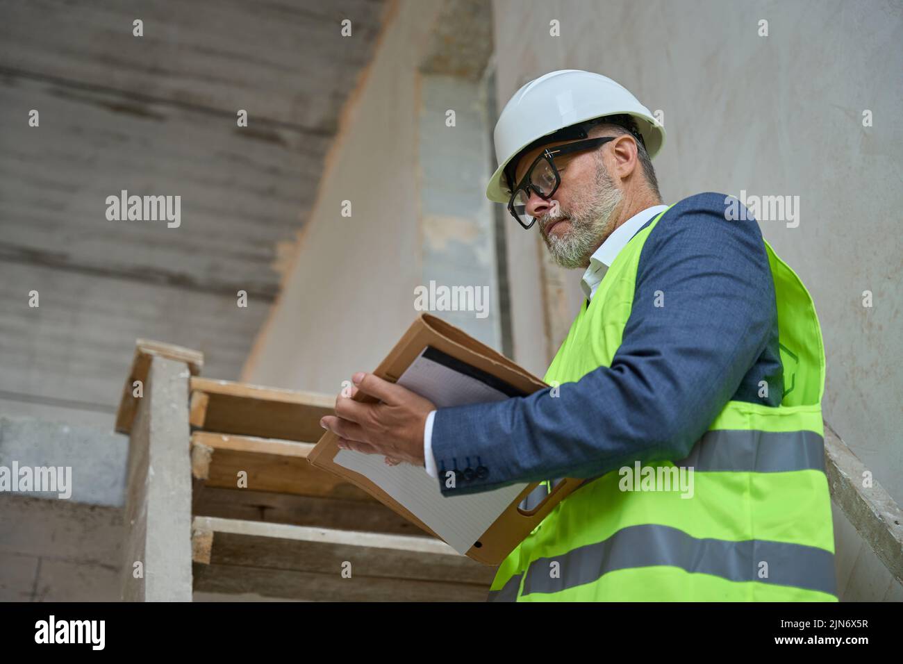 Adult male foreman makes notes in a folder Stock Photo